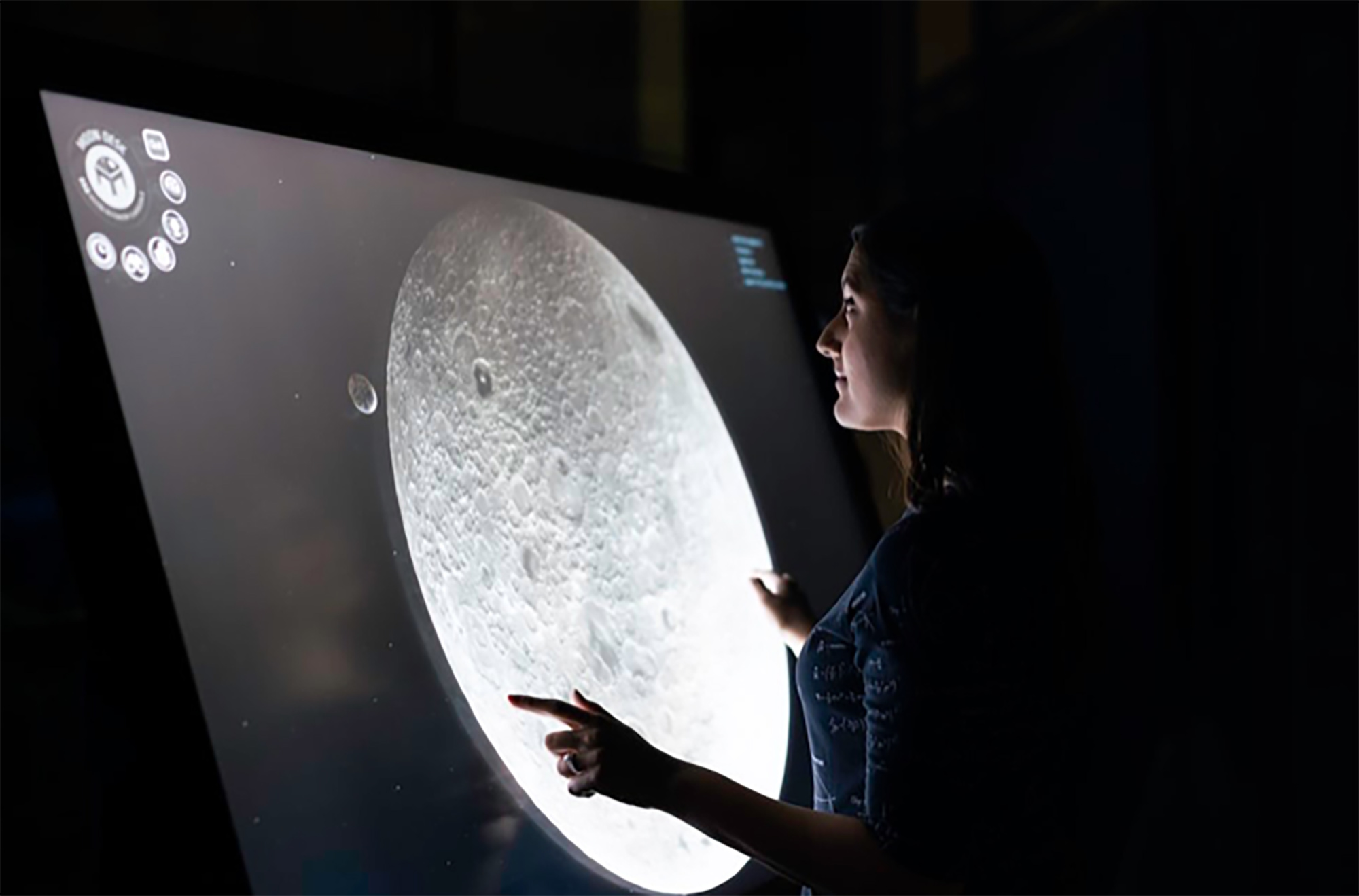 Woman looking at the moon through a tv screen