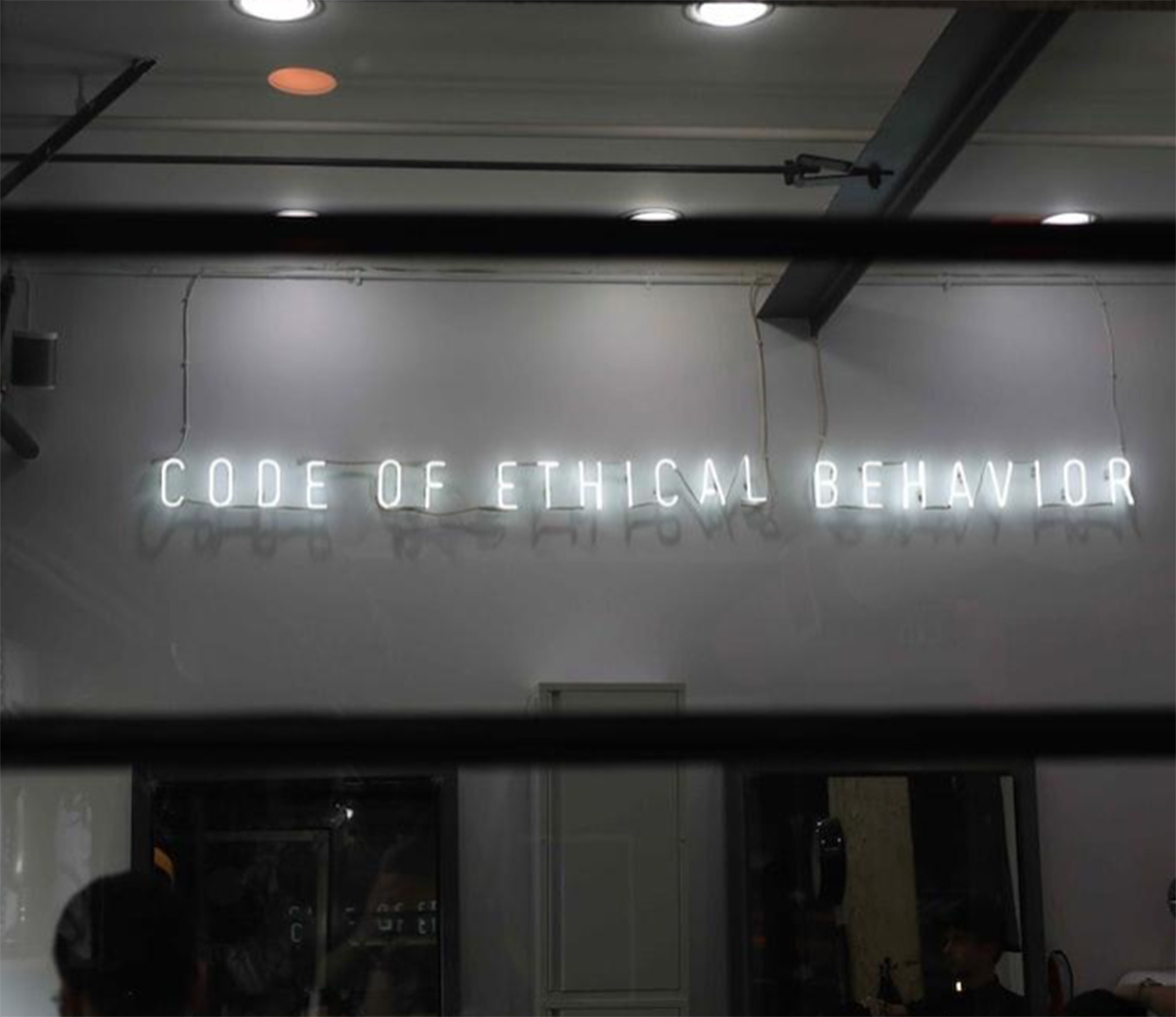 White neon sign that reads "CODE OF ETHICAL BEHAVIOR"