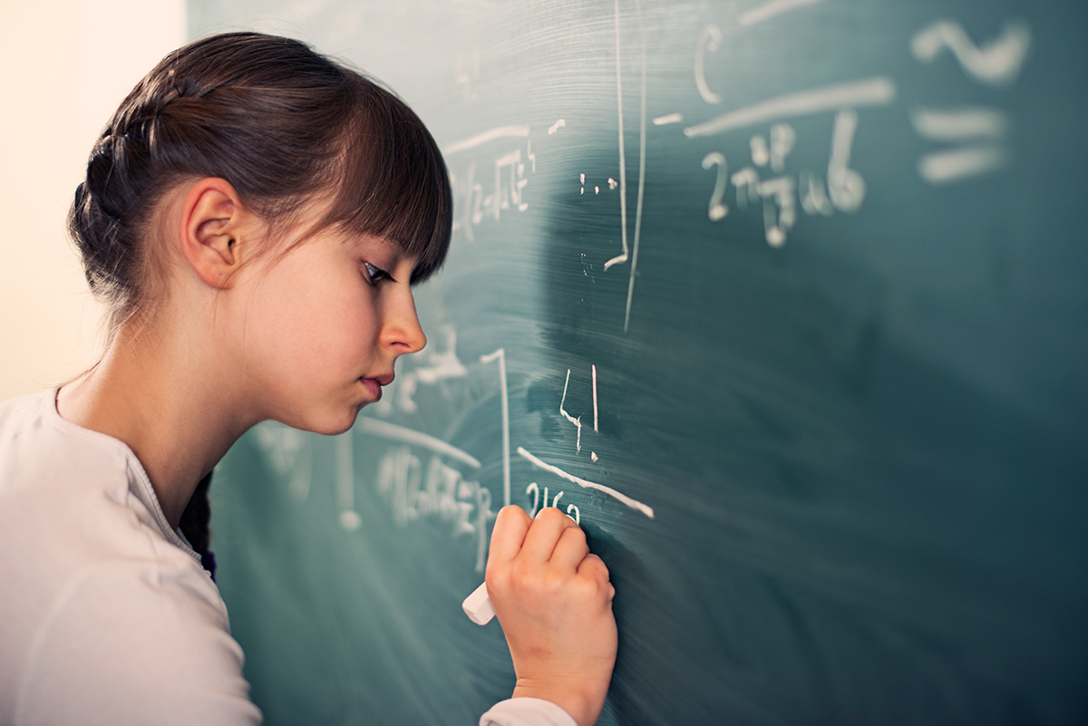 girl doing math problems on a chalkboard