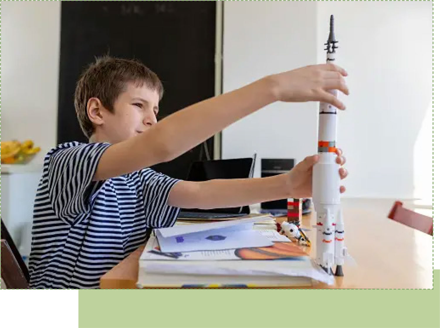 a young boy building a model rocket on a table